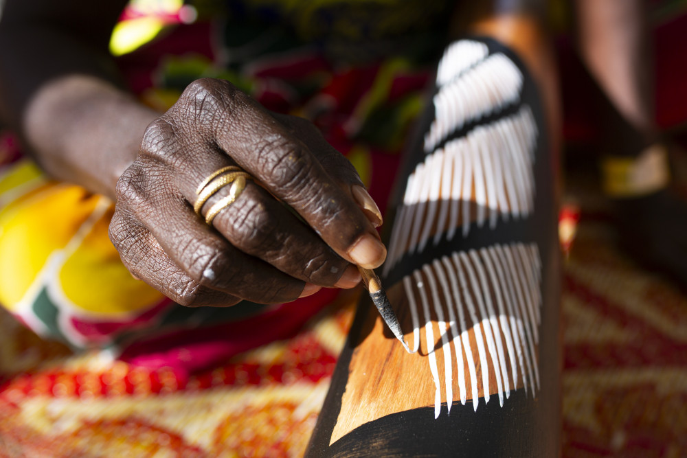 Woman paints a didgeridoo at the Garma Festival