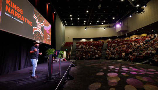 Presenter on stage at conference plenary