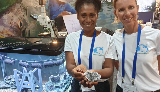 Two delegates holding specimen at conference booth