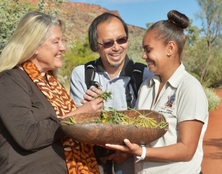 Three people looking at a plant at Alice Springs Desert Park