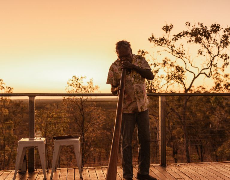 Aboriginal cultural guide performing a didgeridoo at sunset during a Dalabon Aboriginal Cultural Experience in Katherine, Northern Territory.