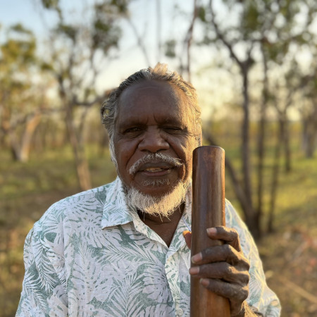Aboriginal cultural guide holding a traditional cultural artefact while standing on Country during a Dalabon Aboriginal Cultural Experience in the Northern Territory.
