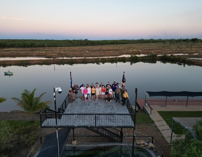 Group of people standing on balcony with body of water in background 