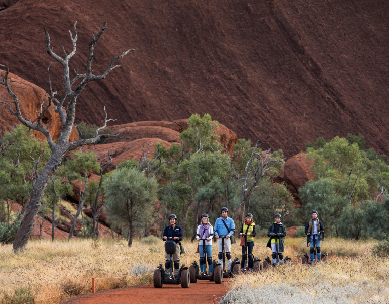 People riding Segways around base of Uluru