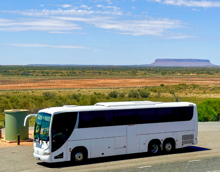 Tour Bus driving on a road through the NT 