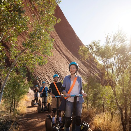 People riding Segways around base of Uluru