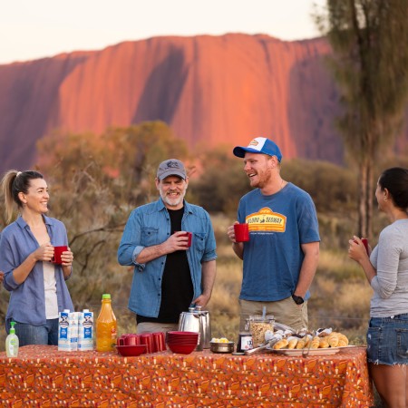 People socialising in front of Uluru
