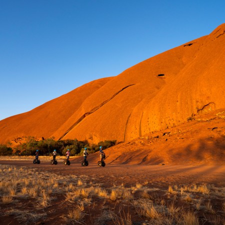 People riding Segways around base of Uluru