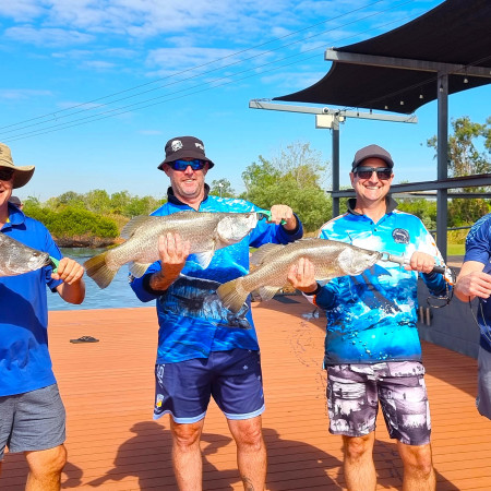 Group holding up caught barramundi