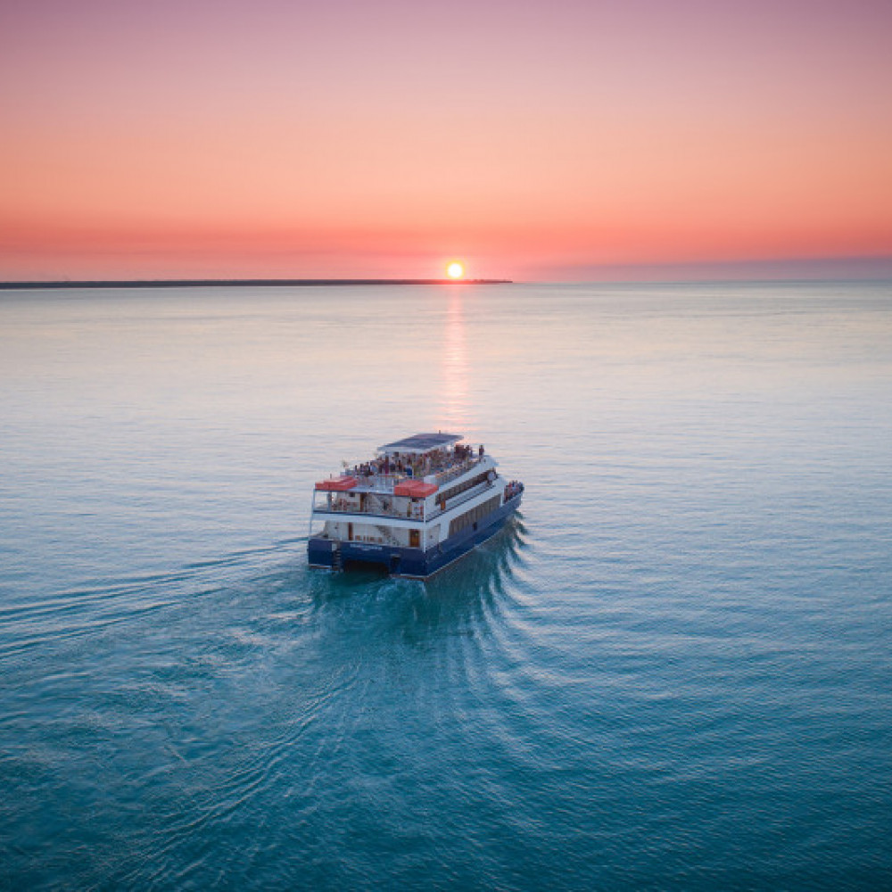 Ariel view of boat on the ocean at sunset 