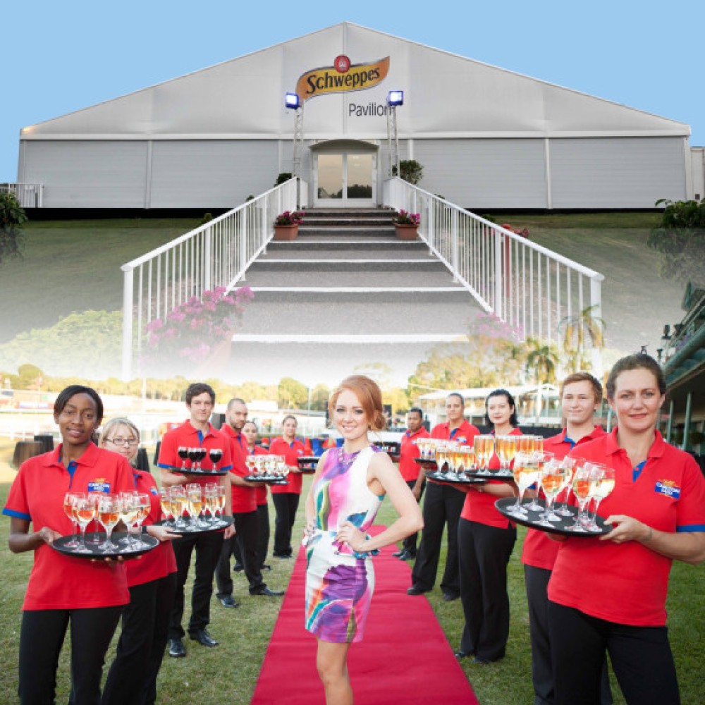 Group of waiters holding champagne at outdoor function venue 
